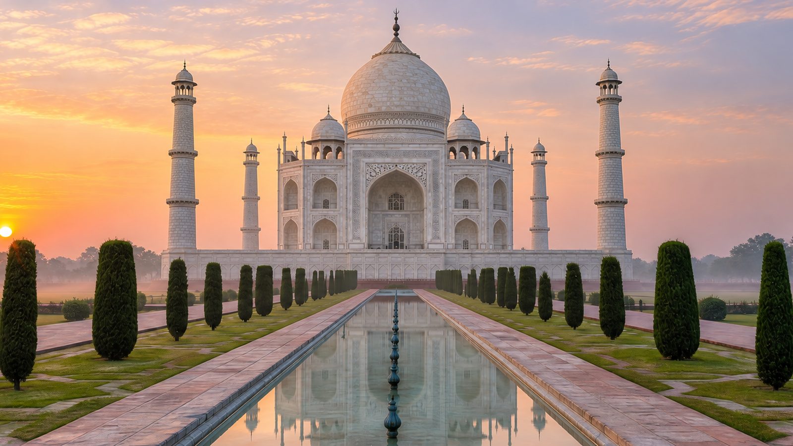The Taj Mahal at sunrise, seen across its reflecting pool