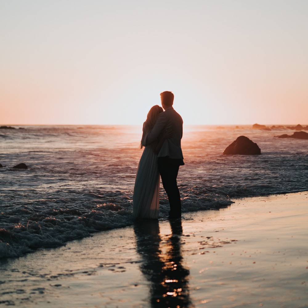 A couple embracing on the beach at sunset